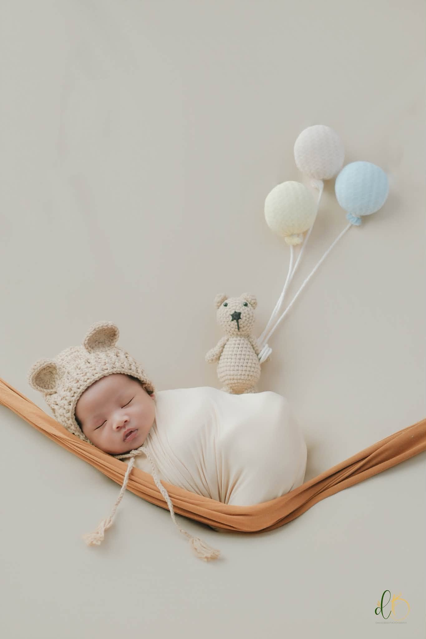 Newborn resting in a soft hammock setup